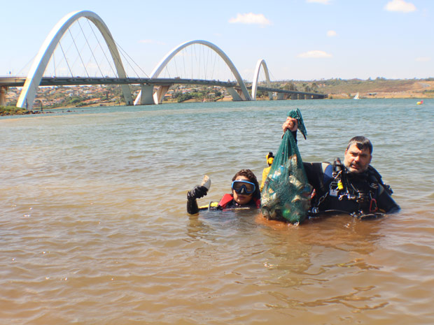 Mergulhadores mostram objetos encontrados no fundo do lago (Foto: Hélio Marinho / TV Globo)
