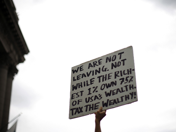 'Não vamos sair. Não enquanto os 1% mais ricos tiverem 75% da riqueza dos EUA. Taxem os ricos!', diz o cartaz (Foto: Reuters / Eric Thayer)