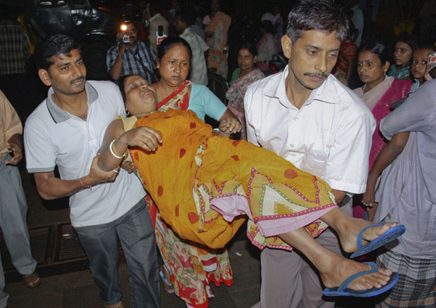 Mulher ferida em desabamento na cidade indiana de Siliguri é carregada para hospital (Foto: Reuters)