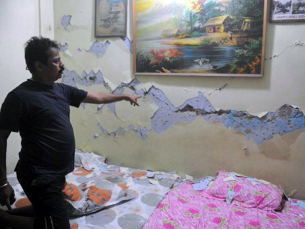 Morador de Siliguri, cidade de Sikkim, na Índia, mostra rachadura provocada por tremor de terra que atingiu o país neste domingo (18). Autoridades contabilizam seis mortos na Índia e cinco no Nepal (Foto: Diptendu Dutta/AFP)