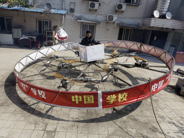  O fazendeiro chinês Shu Mansheng testa o equipamento voador criado por ele mesmo em frente a sua casa, na  vila Dashu, na u na periferia de Wuhan, na província de Hubei, nesta quarta-feira (21). O dispositivo custou mais de 20.000 iuanes (US$ 3.135), é o quinto modelo feito por Shu. Ele mede cerca de 5,5 metros de diâmetro e é equipado com oito motores de motocicleta. Shu conseguiu passar por 10 segundos a cerca de 1 metro  acima do solo durante um vôo de teste recente. (Foto: Reuters)