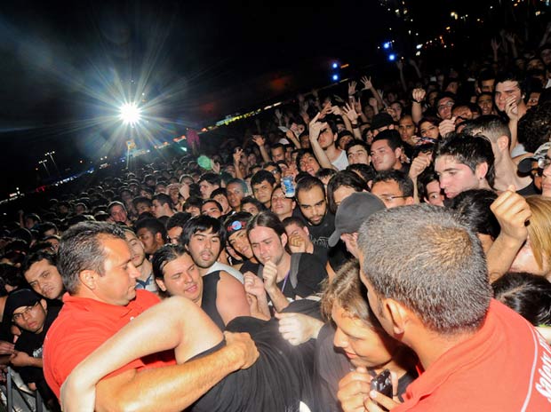 Seguranças retiram fã espremido do meio do público em frente ao Palco Mundo durante show de Motörhead (Foto: Flavio Moraes/G1)