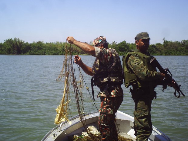 Policial ambiental retira rede do rio Paraguai com a escola de soldado da Marinha (Foto: Divulgação/PMA)