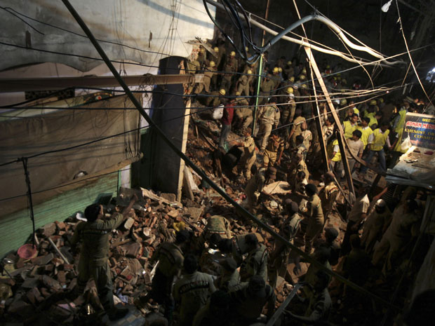 Pessoas trabalham nas buscas por sobreviventes (Foto: Altaf Qadri/AP)