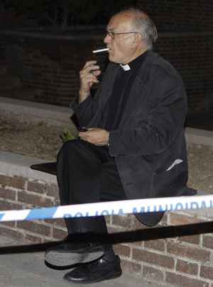 Padre é visto fumando do lado de fora da igreja após incidente (Foto: AP)