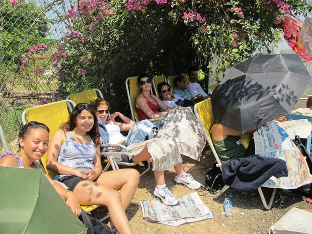 Grupo faz tenda com cangas e descansam em caderias de praia (Foto: Carolina Lauriano / G1)