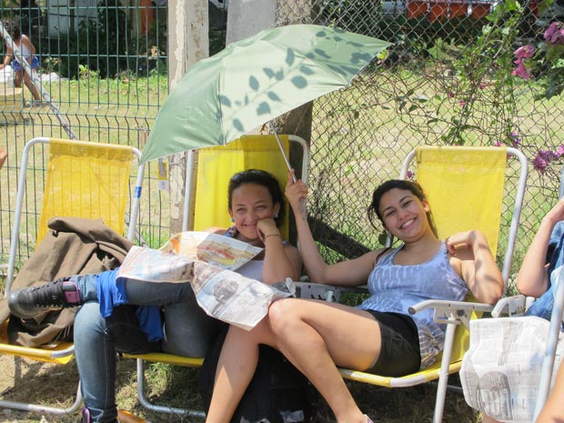 Amigas alugam cadeiras de praia e dividem guarda-chuva para se proteger do sol (Foto: Carolina Lauriano / G1)