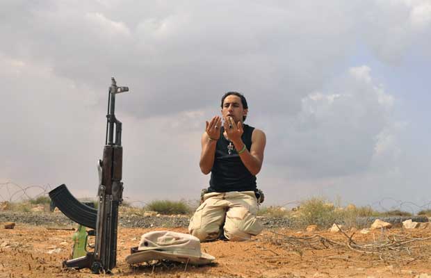 Combatente leal ao novo governo da Líbia ora durante o cerco a Sirte neste sábado (1º) (Foto: AP)