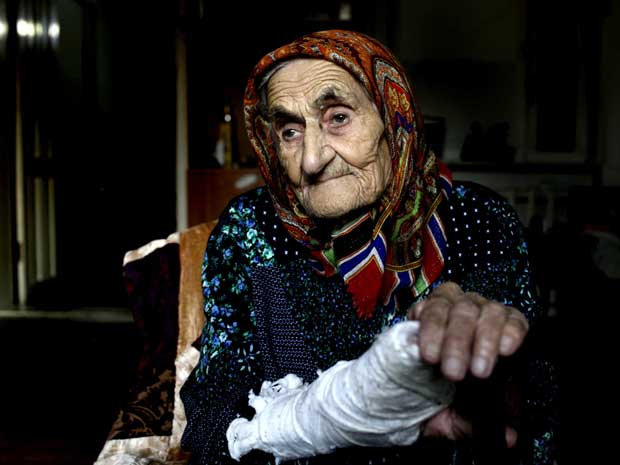 A chechena Kesi Karuyeva, de 116 anos, posa para fotos em 27 de setembro na ciade de Goity, ao sul de Grozny.  (Foto: Reuters)