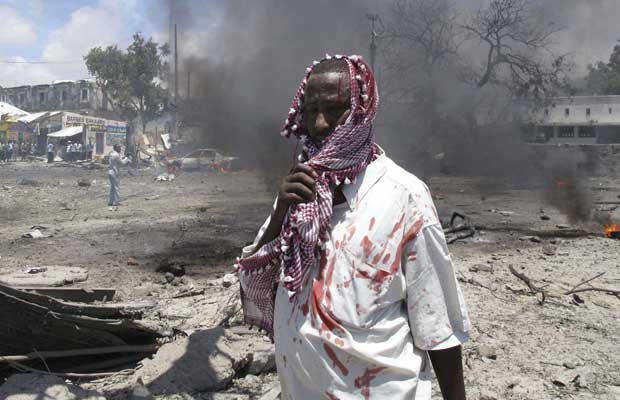 Ferido caminha no local do atentado desta terça-feira (4) em Mogadício, capital da Somália (Foto: AP)