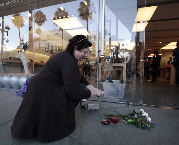 Janine Young, 53, acende uma vela em formato de maçã em homenagem a Steve Jobs em frente a uma loja da Apple em Santa Mônica, na Califórnia (Foto: Lucy Nicholson/Reuters)