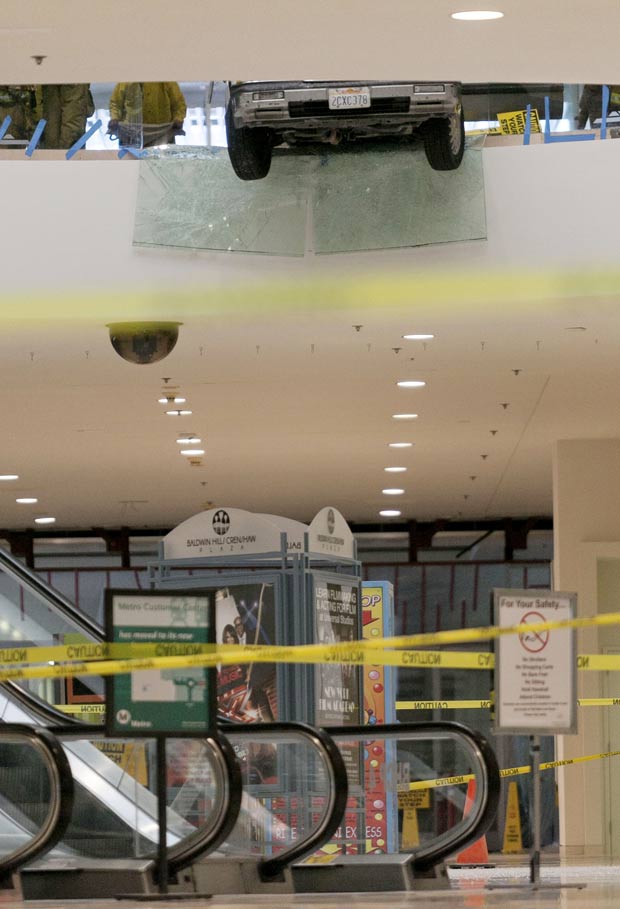 Carro ficou pendurado no segundo andar de um shopping em Los Angeles. (Foto: Damian Dovarganes/AP)