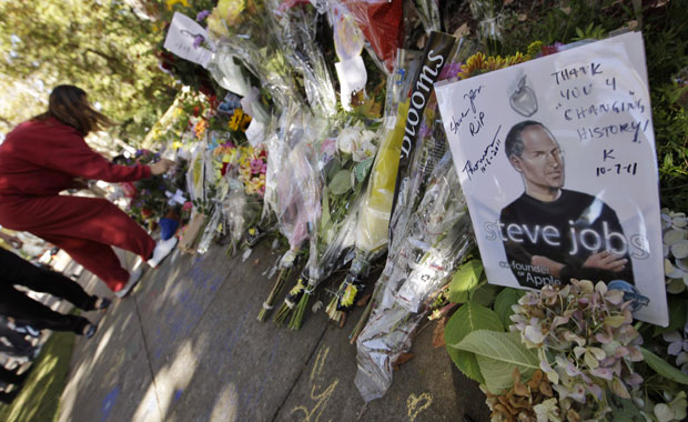Fãs colocam homenagens a Steve Jobs em frente a sua casa em Palo Alto, na Califórnia (Foto: Paul Sakuma/AP)