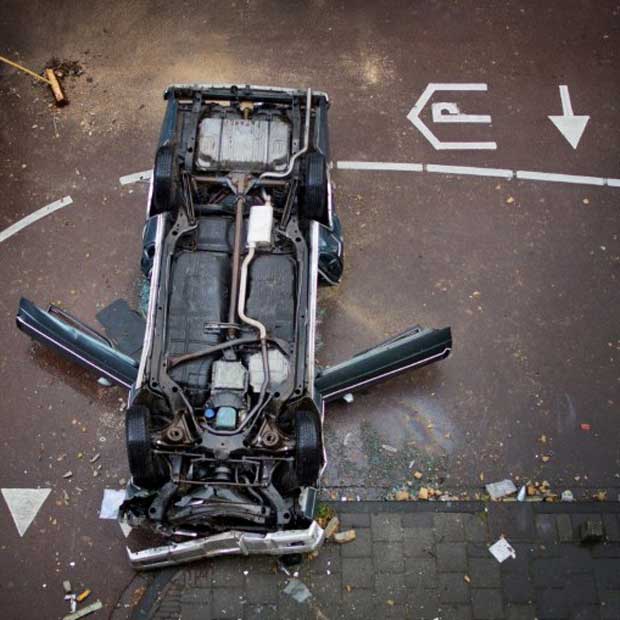 Carro que caiu de ponta-cabeça nesta sexta-feira (7) na cidade holandesa de Leiden. O motorista, um homem de 44 anos, ficou seriamente ferido após dirigir através da parede de uma garagem vertical e cair do terceiro andar (Foto: AFP)