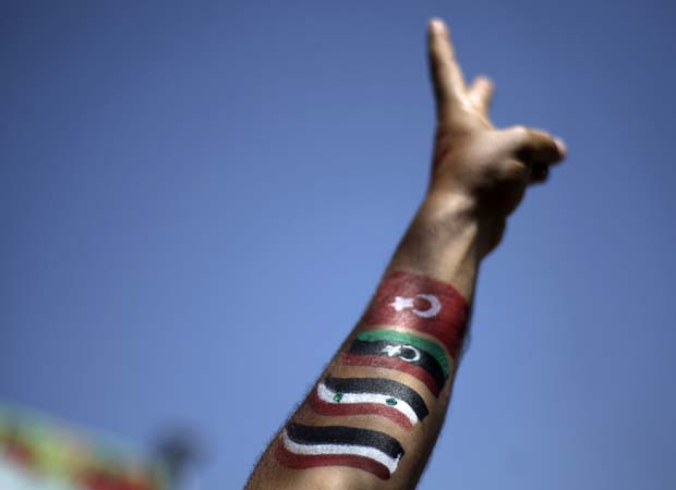 Manifestantes com o braço pintado nas cores de Iêmen, Síria, Líbia e Tunísia faz sinal neste domingo (9) durante protesto antigoverno em Sanaa, capital do Iêmen (Foto: AP)