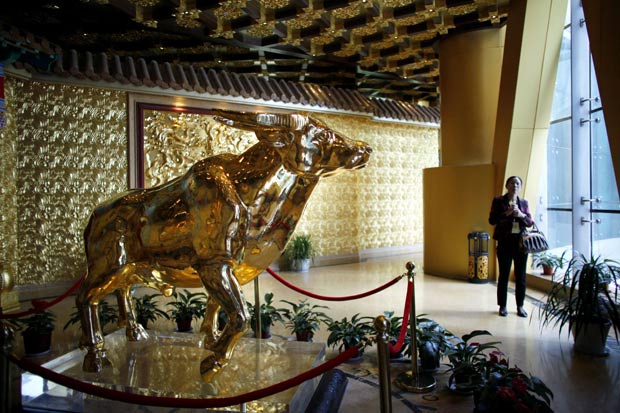 Prédio na China colocou escultura de touro feita com cerca de 1 tonelada de ouro. (Foto: Carlos Barria/Reuters)