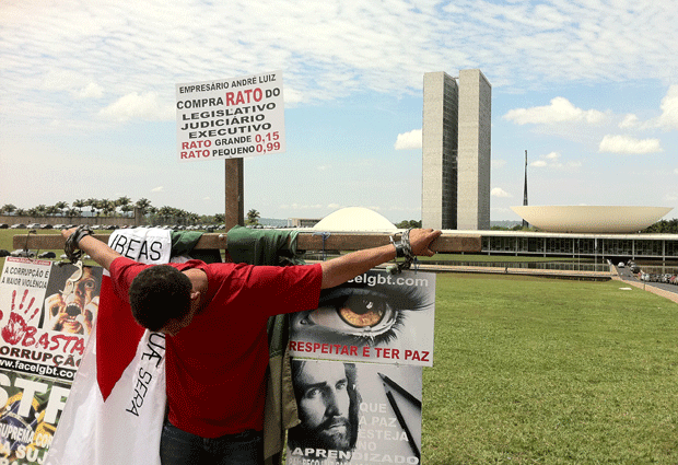 Empresário mineiro se amarra a cruz em frente ao congresso (Foto: Naiara Leão/ G1)
