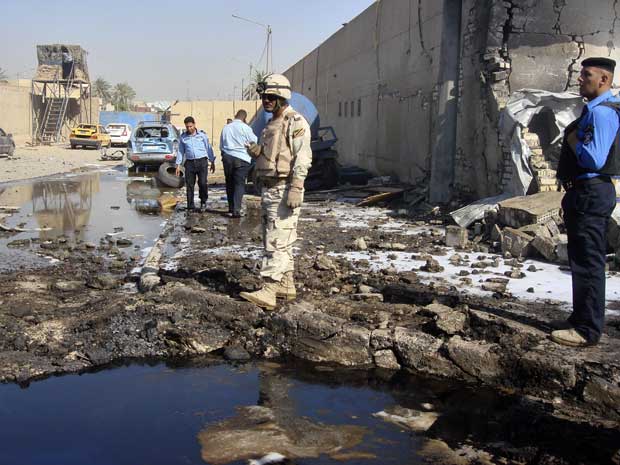 Soldados e policiais inspecionam o local de um ataque a bomba em uma delegacia no distrito de Hurriya de Bagdá. (Foto: Reuters)