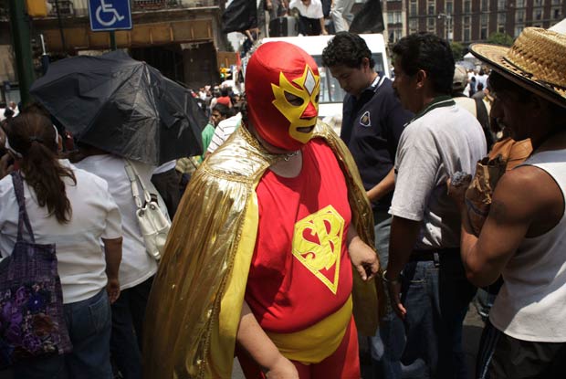 Usando uma máscara de luta livre, um mexicano que se autoproclama 'Super Bairro' tenta promover melhorias nos bairros pobres da Cidade do México.  (Foto: Arnulfo Franco/AP)