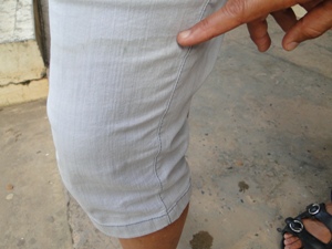 Funcionária mostra marca da água do rio em sua calça (Foto: Tatiana Dourado/G1BA)