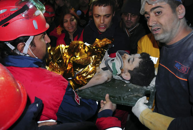O menino de 11 anos é socorrido pelos oficiais de resgate (Foto: Reuters/Stringer)