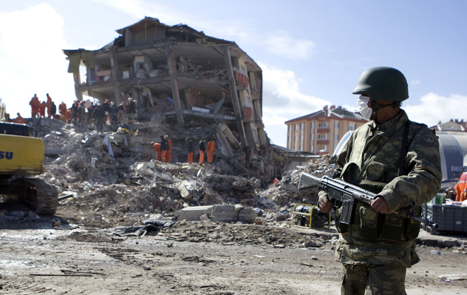 Soldado guarda local onde oficiais de resgate seguem à procura de sobreviventes em Ercis, cinco dias depois do terremoto