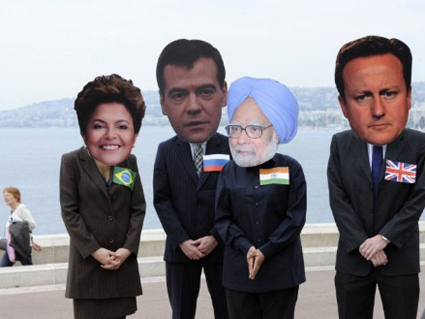 Ativistas usam máscaras da presidente do Brasil, Dilma Rousseff, russo Dimitri Medvedev, primeiro-ministro indiano, Manmohan Singh, e primeiro-ministro britânico, David Cameron. (Foto: AFP)