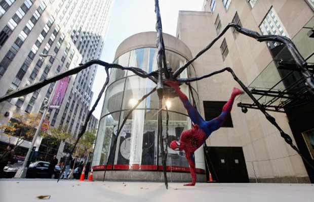 Ator fantasiado de Homem-Aranha faz performance nesta sexta-feira (4) ao lado da escultura 'Aranha', da francesa Louise Bourgeois, em frente à casa de leilões Christie's, em Nova York (Foto: AFP)