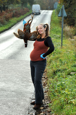Alison posa com um faisão recém-apanhado da estrada em frente a sua casa (Foto: Caters)