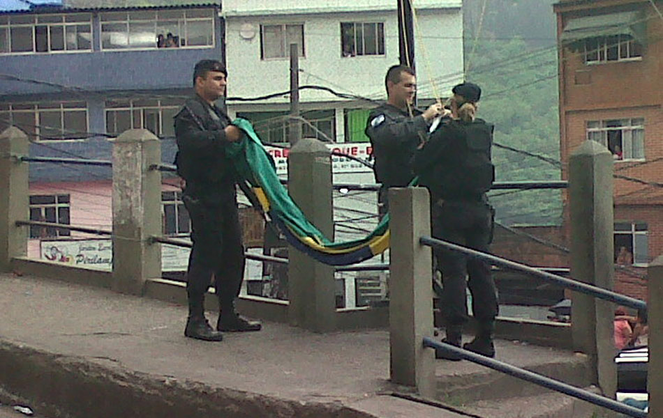 Oficiais preparam bandeira para ser erguida simbolizando a pacificação do morro
