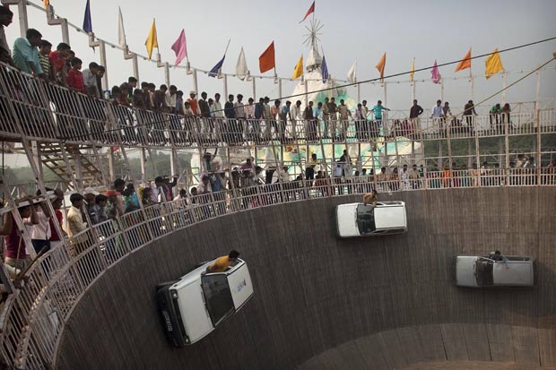 Indianos encaram atração conhecida como 'Poço da Morte'. (Foto: Kevin Frayer/AP)