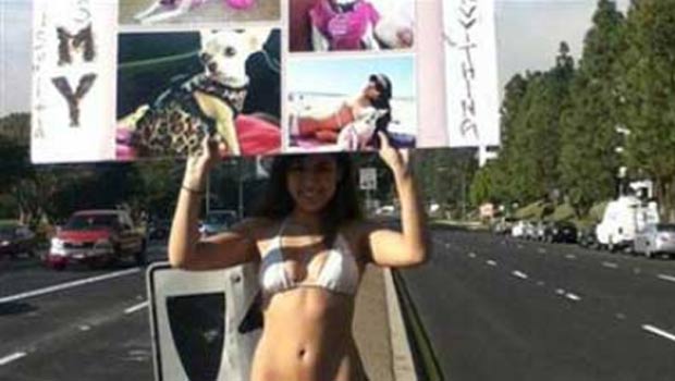 Com biquíni e salto alto, Arlene Mossa Corona segurava cartaz com fotos de cadela. (Foto: Reprodução)