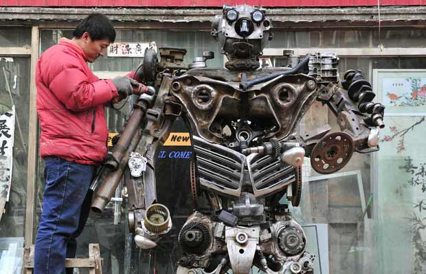 O trabalhador Huang Lianfei faz escultura inspirada no desenho 'Transformers', na cidade chinesa de Shenyang, província de Liaoning. Ele levou um mês para fazer a obra, só com peças usadas de carros (Foto: Sheng Li/Reuters)
