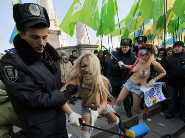 Integrantes do movimento feminista Femen, da Ucrânia, protestam contra reunião de partidos da oposição na capital Kiev. Policiais tentam remover ativistas do local, que resistem (Foto: AFP)