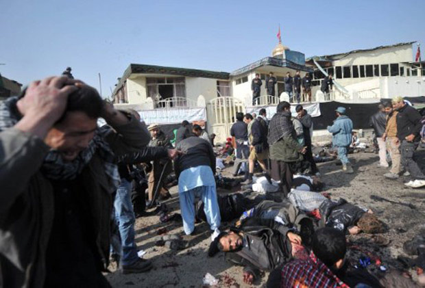 Homem se desespera ao ver corpos de vítimas de explosão em mesquita xiita em Cabul (Foto: Massoud Hossani / AFP)