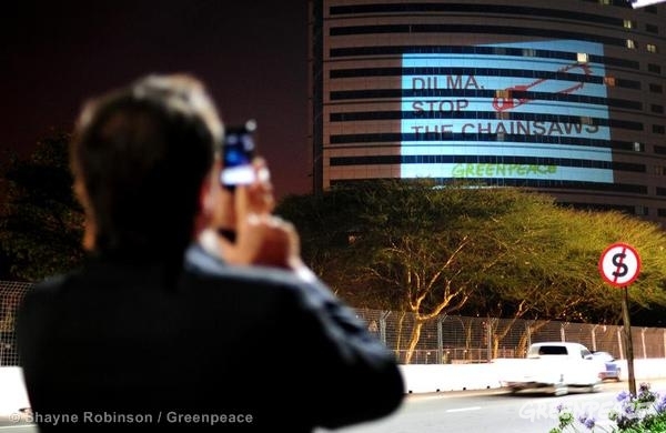 Imagem projetada em hotel de Durban, próximo ao local da COP 17, mostra imagem de motosserra e mensagem de protesto contra a votação do Código Florestal (Foto: Divulgação/Shayne Robinson/Greenpeace)