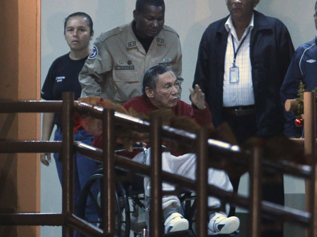 Ex-ditador panamenho Manuel Antonio Noriega gesticula ao ser levado em cadeira de rodas na Cidade do Panamá (Foto: Esteban Felix/AP)