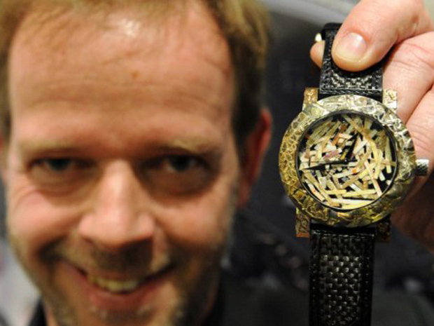 Fabricante de relógios suíço Yvan Arpa mostra um modelo feito com notas de euro picadas durante o lançamento da sua marca ArtyA em Sidney, na Austrália (Foto: AFP)