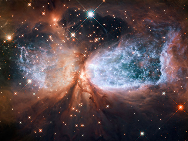 A imagem obtida pelo telescópio espacial Hubble mostra Sh 2-106, uma região formadora de estrelas. Uma jovem estrela chamada S106 IR expele material a uma velocidade muito alta, espalhando gás e poeira em seu redor. A estrela, que tem aproximadamente 15 vezes a massa do Sol, vai se estabilizar em breve e começar sua fase adulta. Ela continua dentro de sua ‘nuvem-mãe’, mas se rebela contra ela. O material expelido deixa o hidrogênio em volta muito quente – até 10 mil graus Celsius – e turbulento. (Foto: Nasa/ESA/Hubble Heritage Team (STScI/AURA))