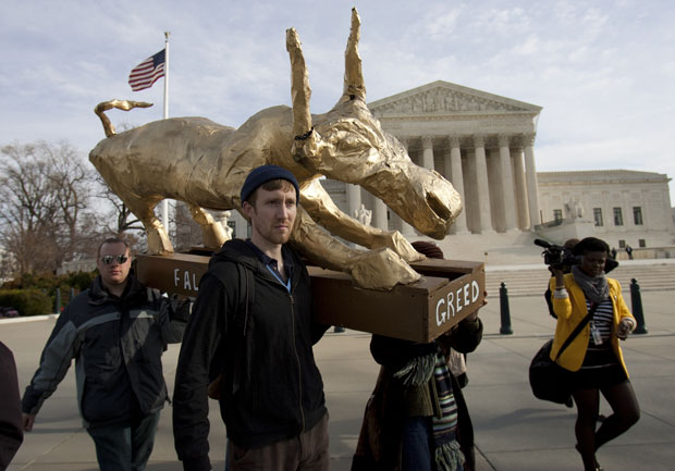 Manifestantes chegam à frente do Capitólio com o bezerro dourado (Foto: Toby Jorrin/AFP)