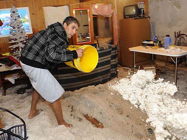 Desempregado tira o gelo que atingiu sua casa em Caxias do Sul após tempestade  (Foto: Daniela Xu/Agência RBS)
