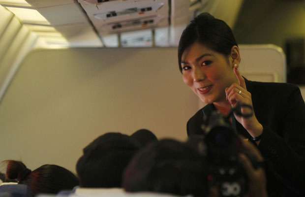 Nathatai Sukkaset, de 26 anos, conversa com passageiros durante o voo nesta quinta-feira (15)  (Foto: Reuters)