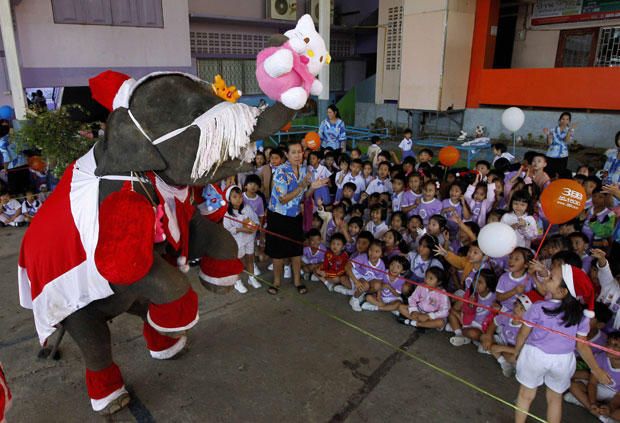 Crianças comemoram a distribuição de presentes pelo 'Elefante Noel' (Foto: Sukree Sukplang/Reuters)