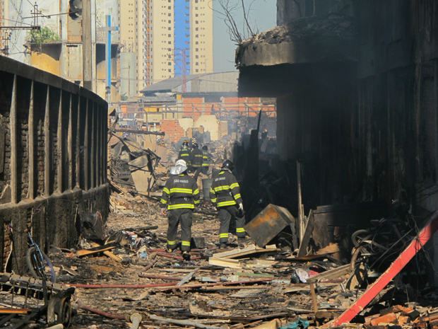 Bombeiros trabalham em favela no dia seguinte a incêndio (Foto: Letícia Macedo/G1)