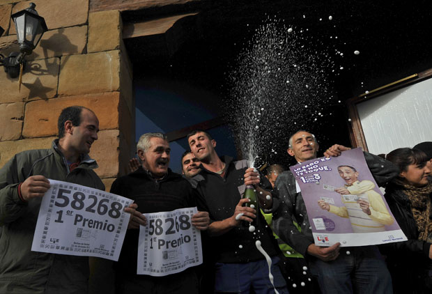 Moradores de Granen estouram champagne para comemorar a premiação (Foto: AP)