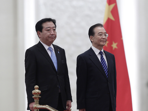Yoshihiko Noda (à esquerda) e Hu Jintao escutam os hinos nacionais do Japão e da China. (Foto: Jason Lee / Reuters)