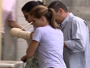 Jovem baleada no carro de Adriano chega à delegacia da Barra da Tijuca (Foto: Reprodução TV Globo)