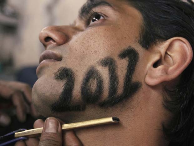 Homem corta a barba no formato do número 2012, em uma homenagem ao Ano Novo, em barbearia de Ahmedabad, na Índia, nesta sexta-feira (30) (Foto: Amit Dave/Reuters)