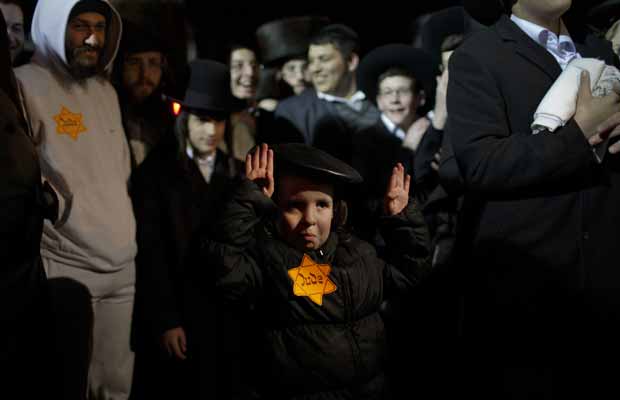 Menino judeu ultraortodoxo usa estrela amarela em Mea Shearim, em Jerusalém, neste sábado (31) (Foto: AP)