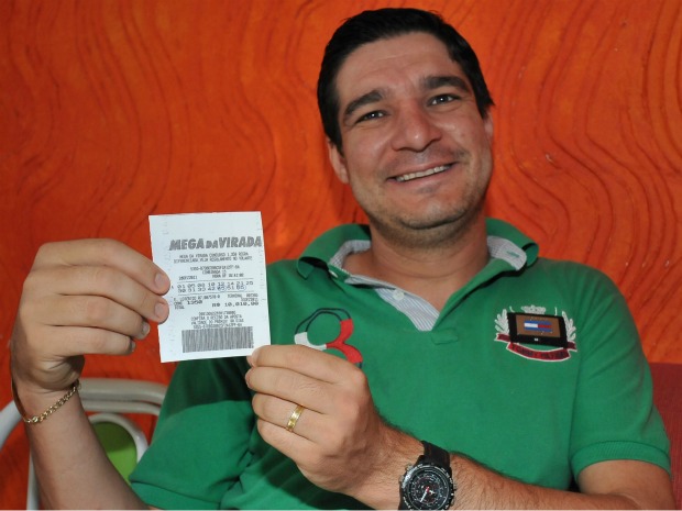 Fotógrafo Ademir Almeida e o bilhete de 15 números que custou R$ 10.010 a grupo (Foto: Mirian Fidélis/Arquivo pessoal)